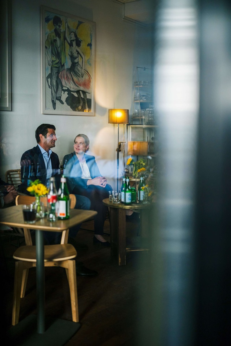 Politikerporträt: Kandidat im Gespräch mit einer Kollegin in einem Café